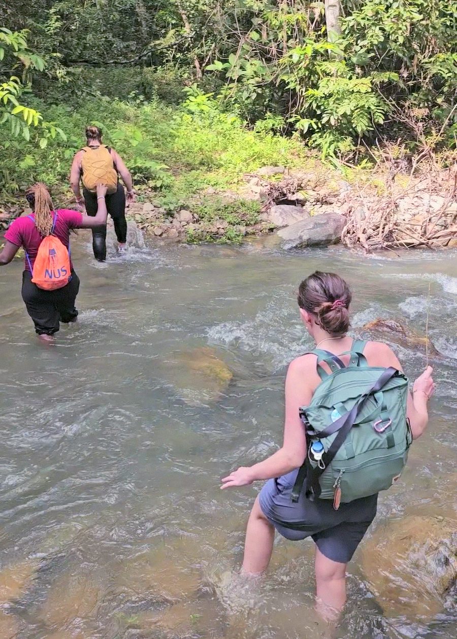 Two friends sharing ice pops by the jungle river after the trek