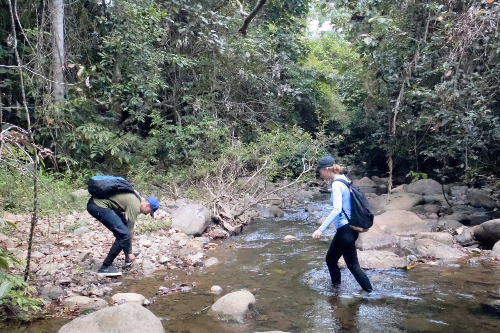 Trekkers crossing a shallow rocky stream