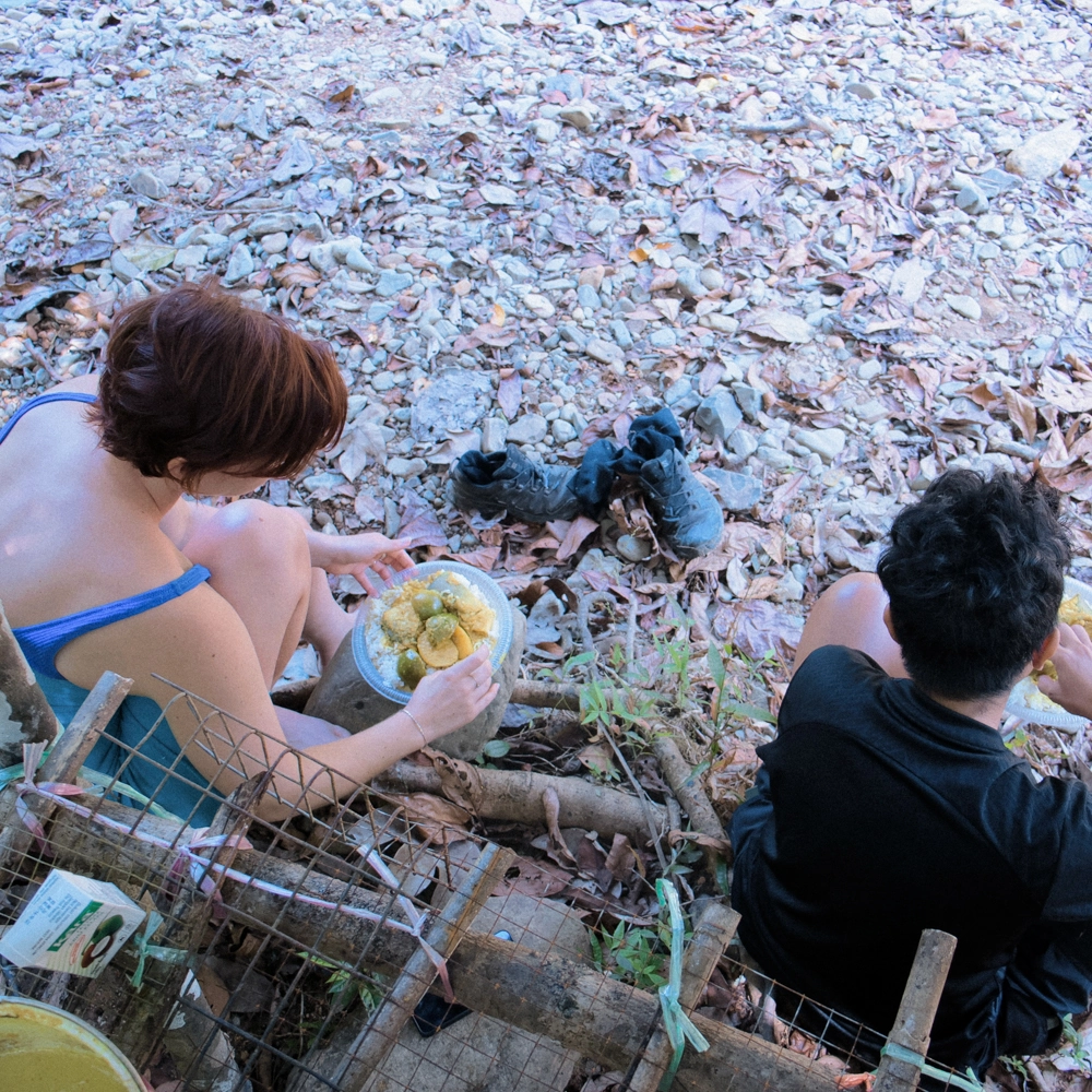 Guests enjoying freshly cooked food at the rocky pond