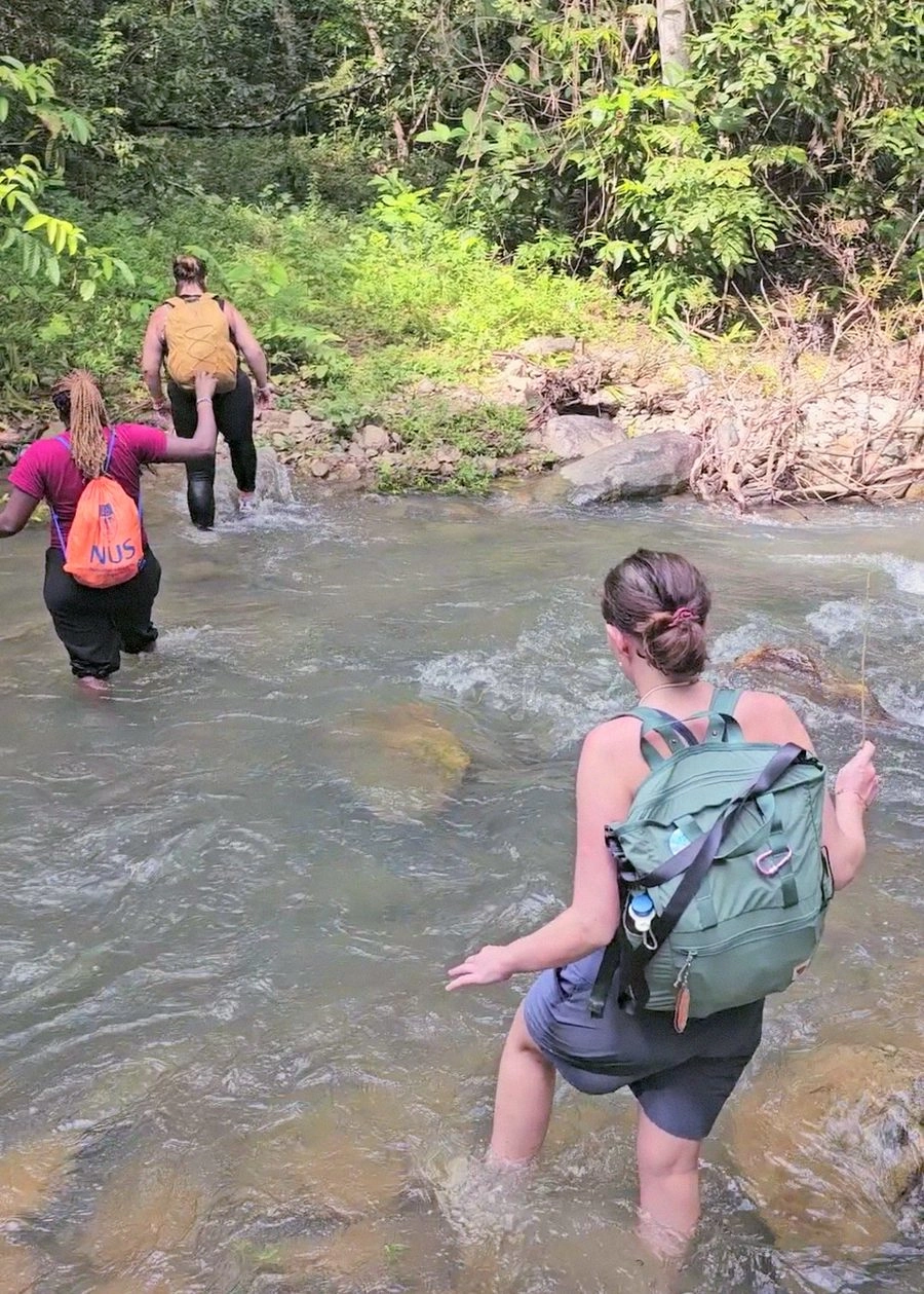 Two friends sharing ice pops by the jungle river after the trek