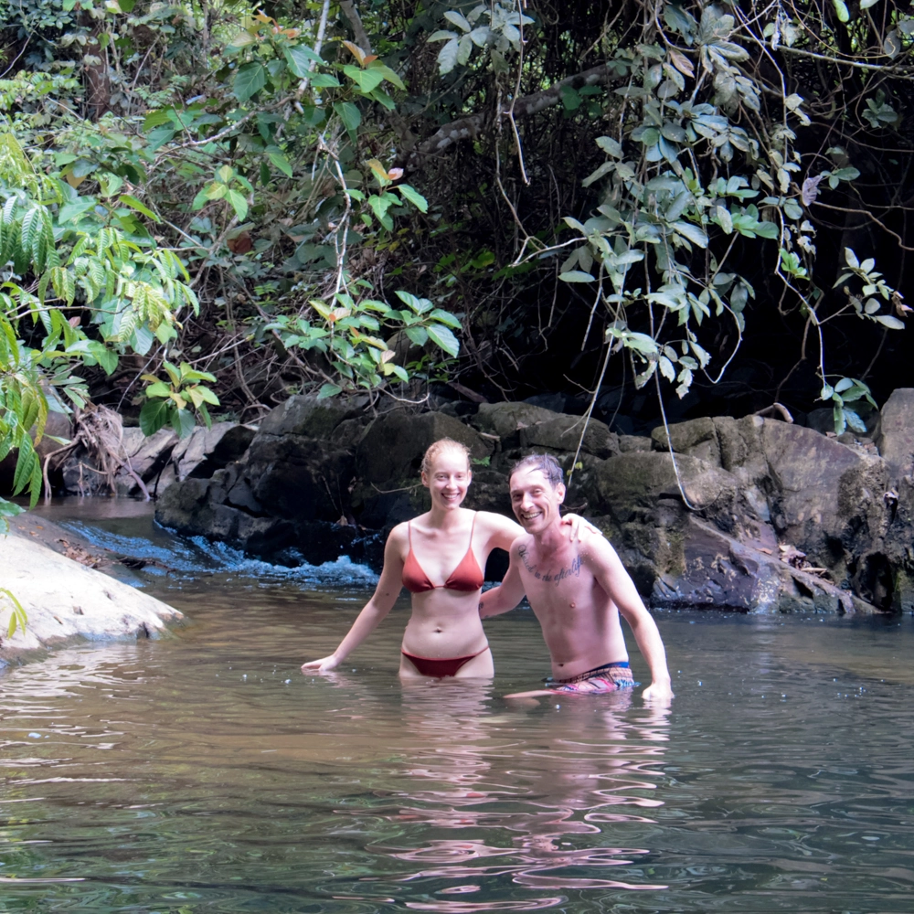 Guest swimming in the clear rocky freshwater pool deep in the jungle